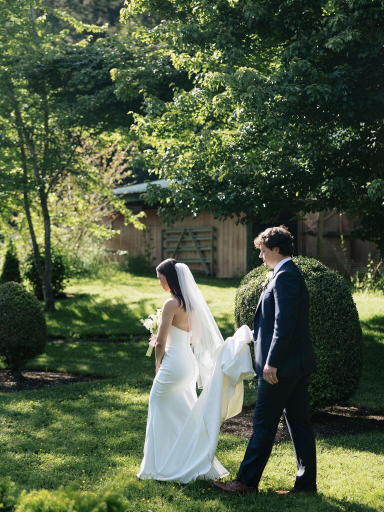 Bride and groom walking through the gardens together.