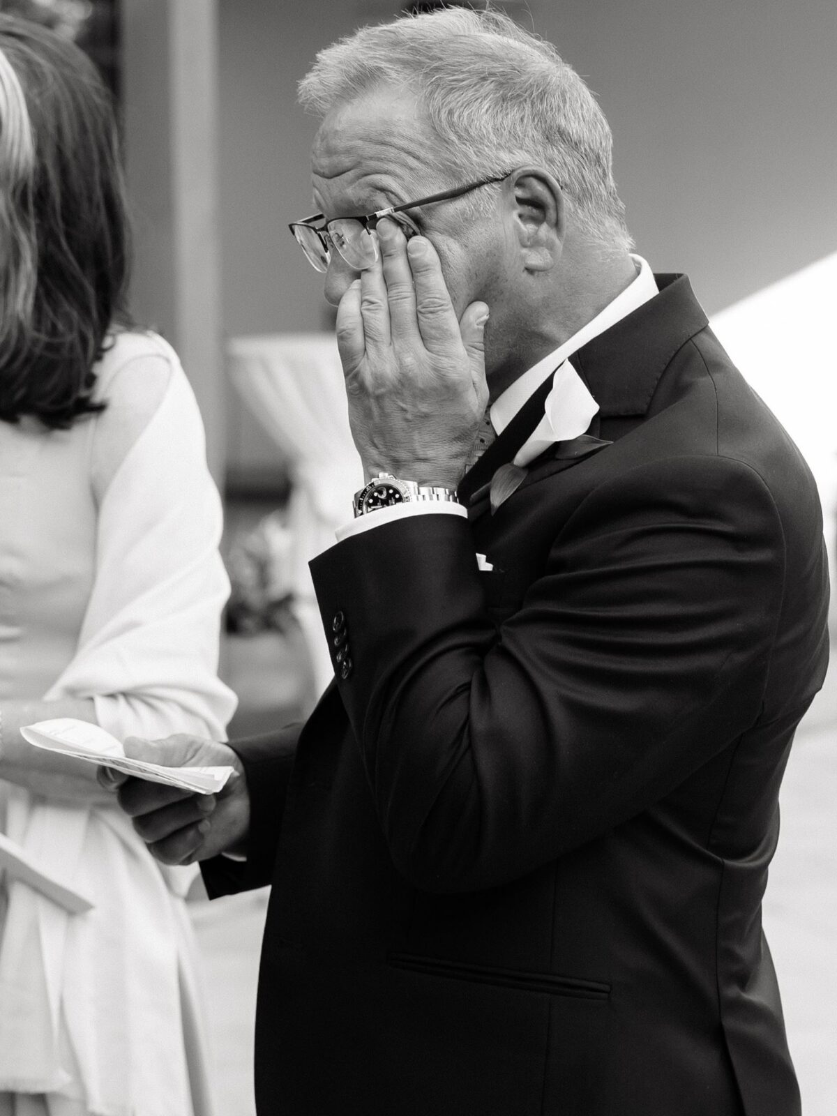 Black and white photo of a guts getting emotional as he gives a speech.