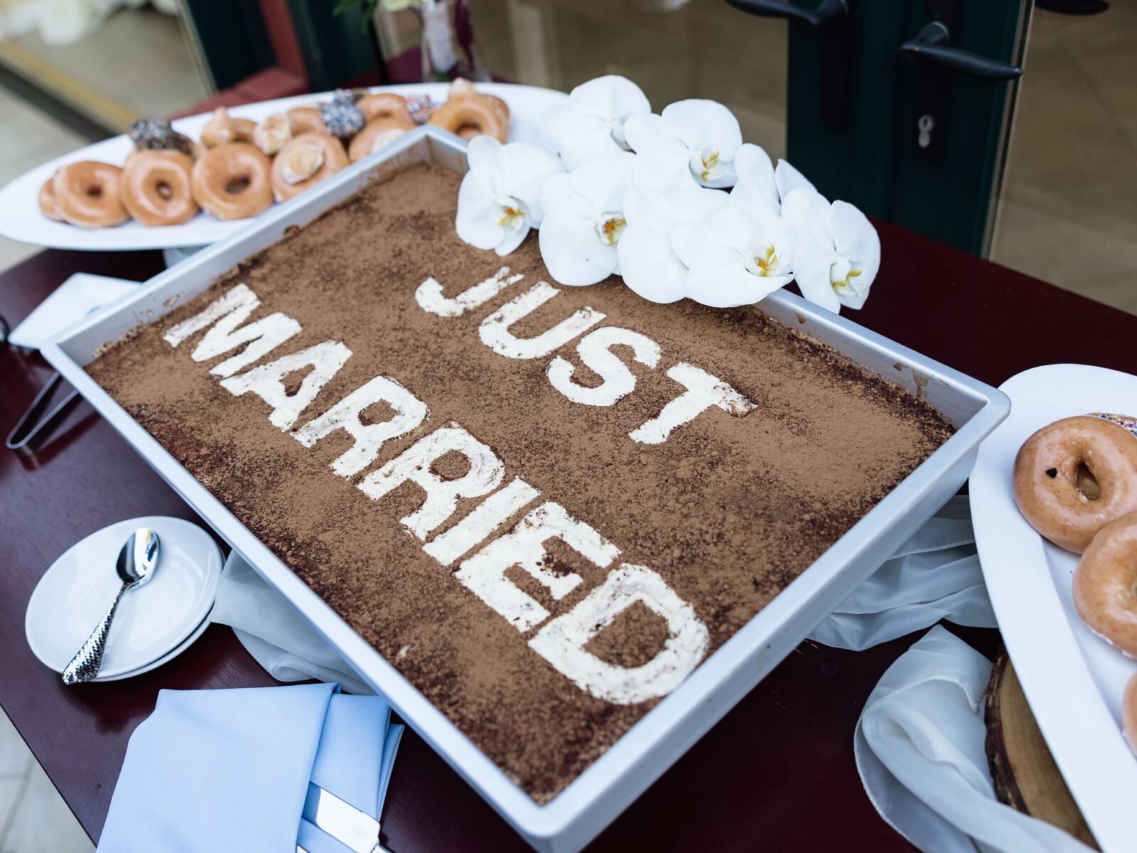 a Just Married wedding cake with donuts on the side.