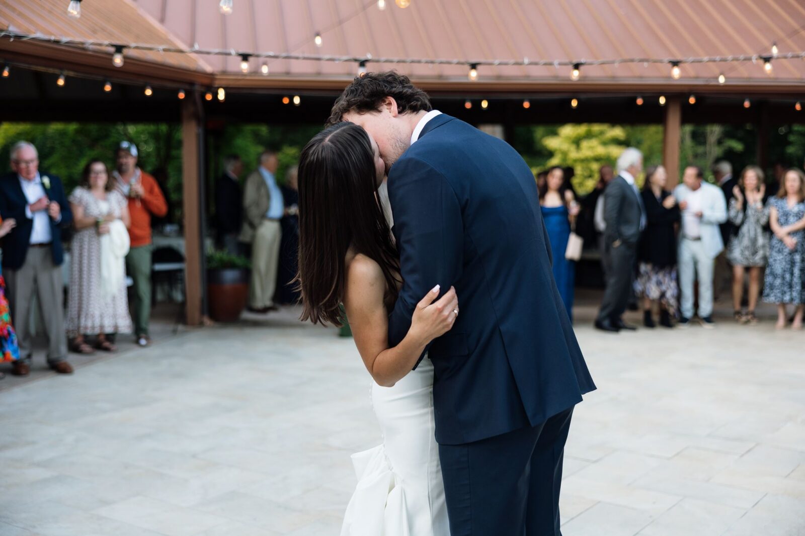 Bride and groom kissing during their first dance at Froggsong Gardens.
