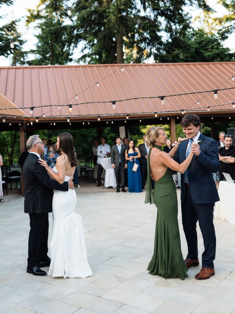 Bride dancing with her father and groom dancing with his mother.