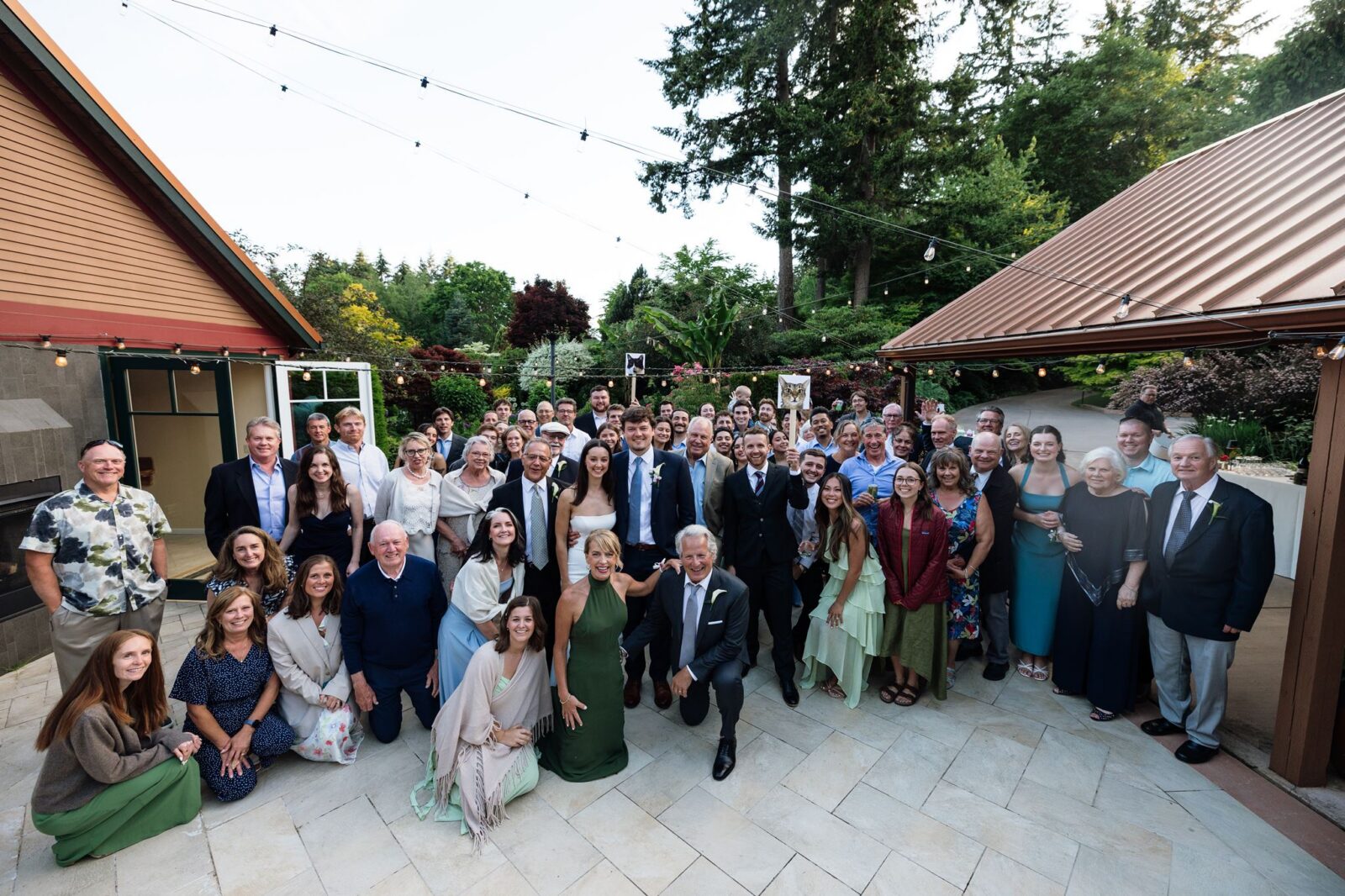 Large group shot of wedding guests posing for a photo at Froggsong Gardens in Vashon Island, WA.