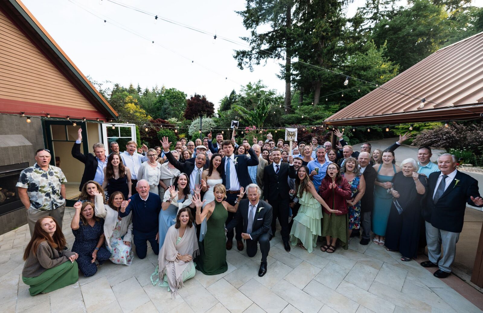 Large group shot of wedding guests posing for a photo at Froggsong Gardens in Vashon Island, WA.
