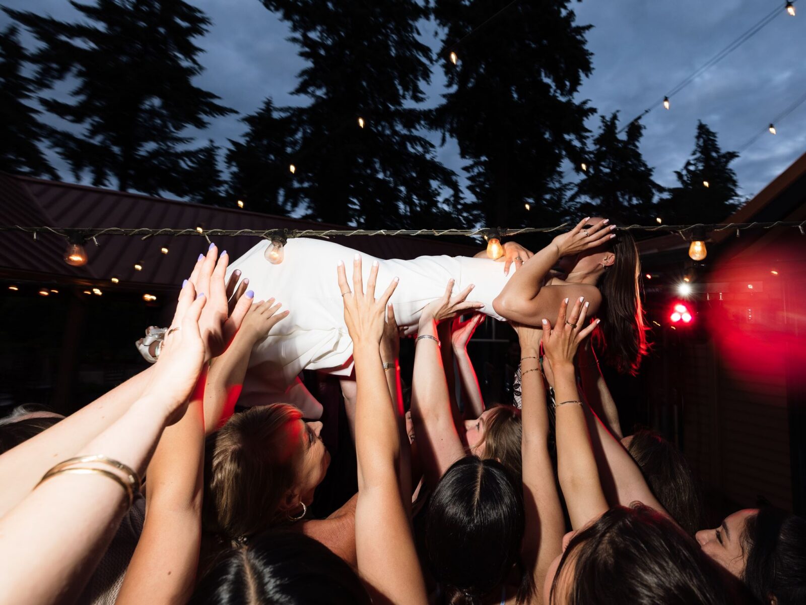 Bride crowd surfing above wedding guests during the reception.
