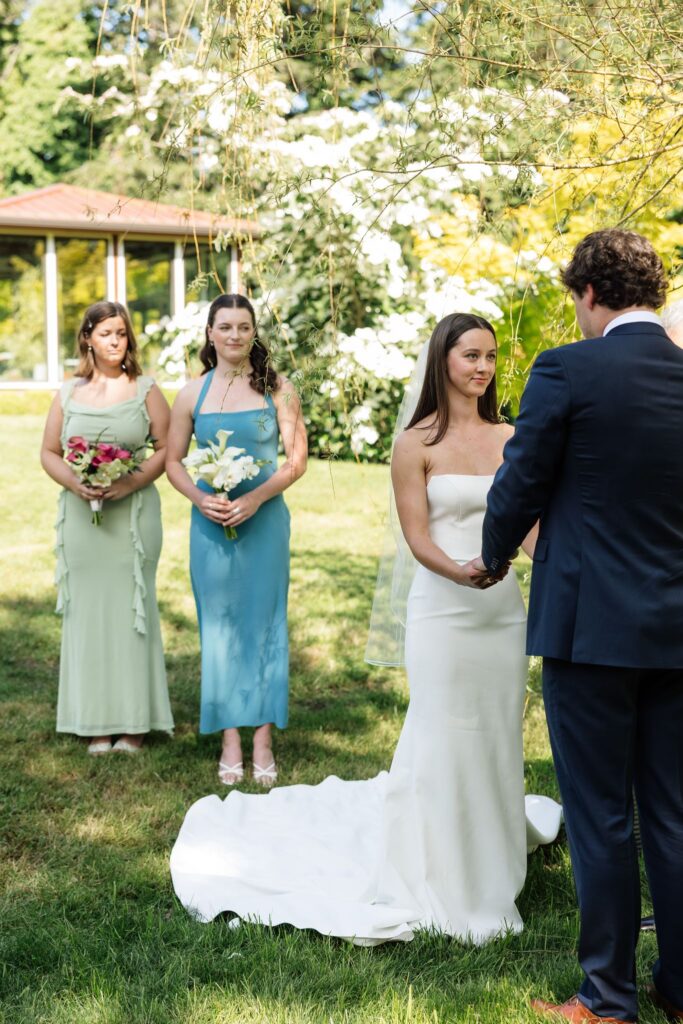 Bride and groom holding hands during their garden wedding ceremony.