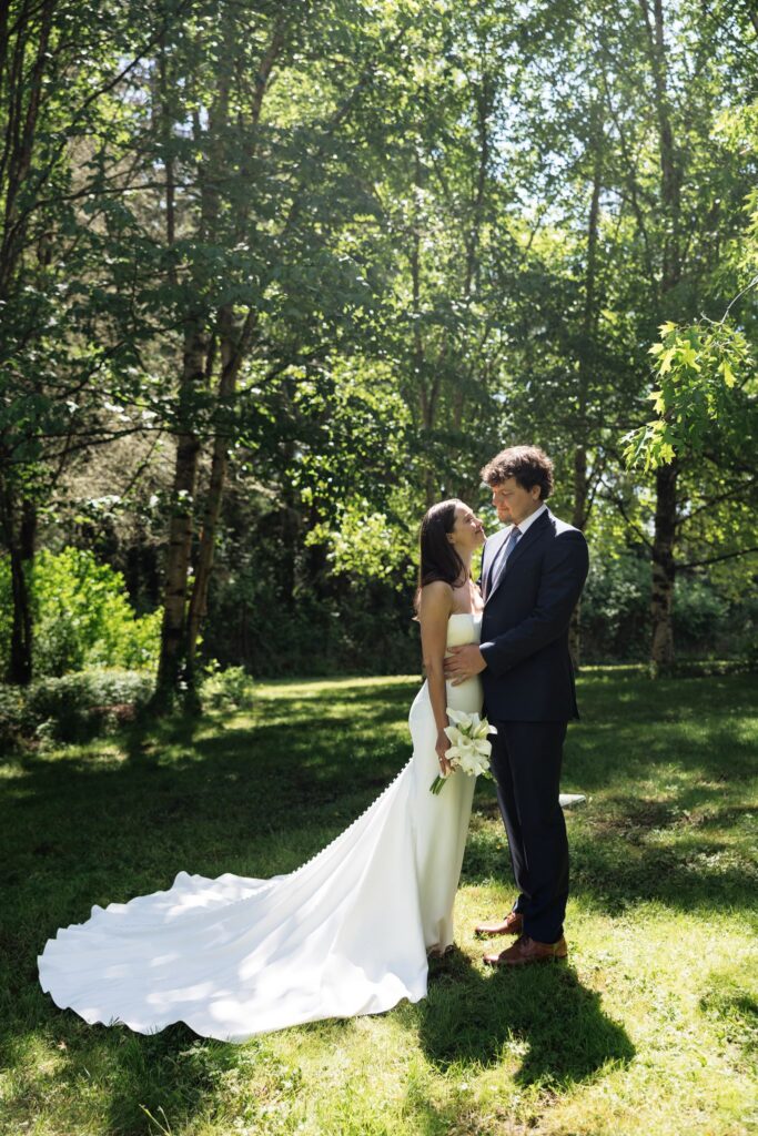 Bride and groom smiling at one another during their potraits.