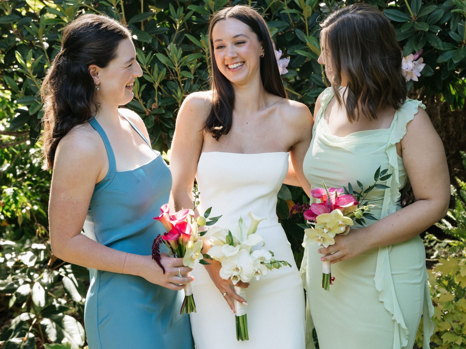 Candid photo of a bride and bridesmaids laughing during portraits.