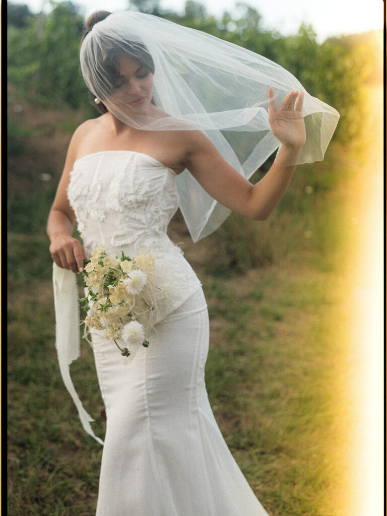 Bridal portrait with a short veil, strapless wedding dress, and white floral bouquet at Maysara Winery.