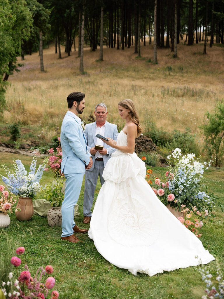 Outdoor Maysara Winery ceremony with a couple standing at the altar surrounded by colorful florals and golden hills.