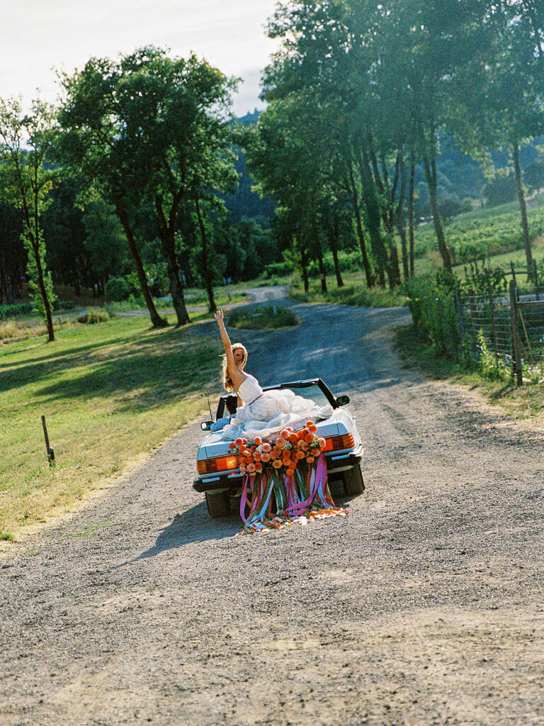 Bride and groom driving down a dirt path during their Maysara Winery wedding photos.