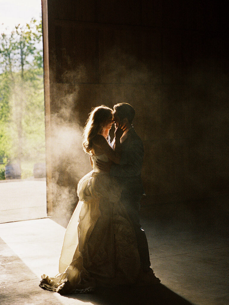 Couple dancing inside Maysara Winery as sunlight streams through the open winery doors.