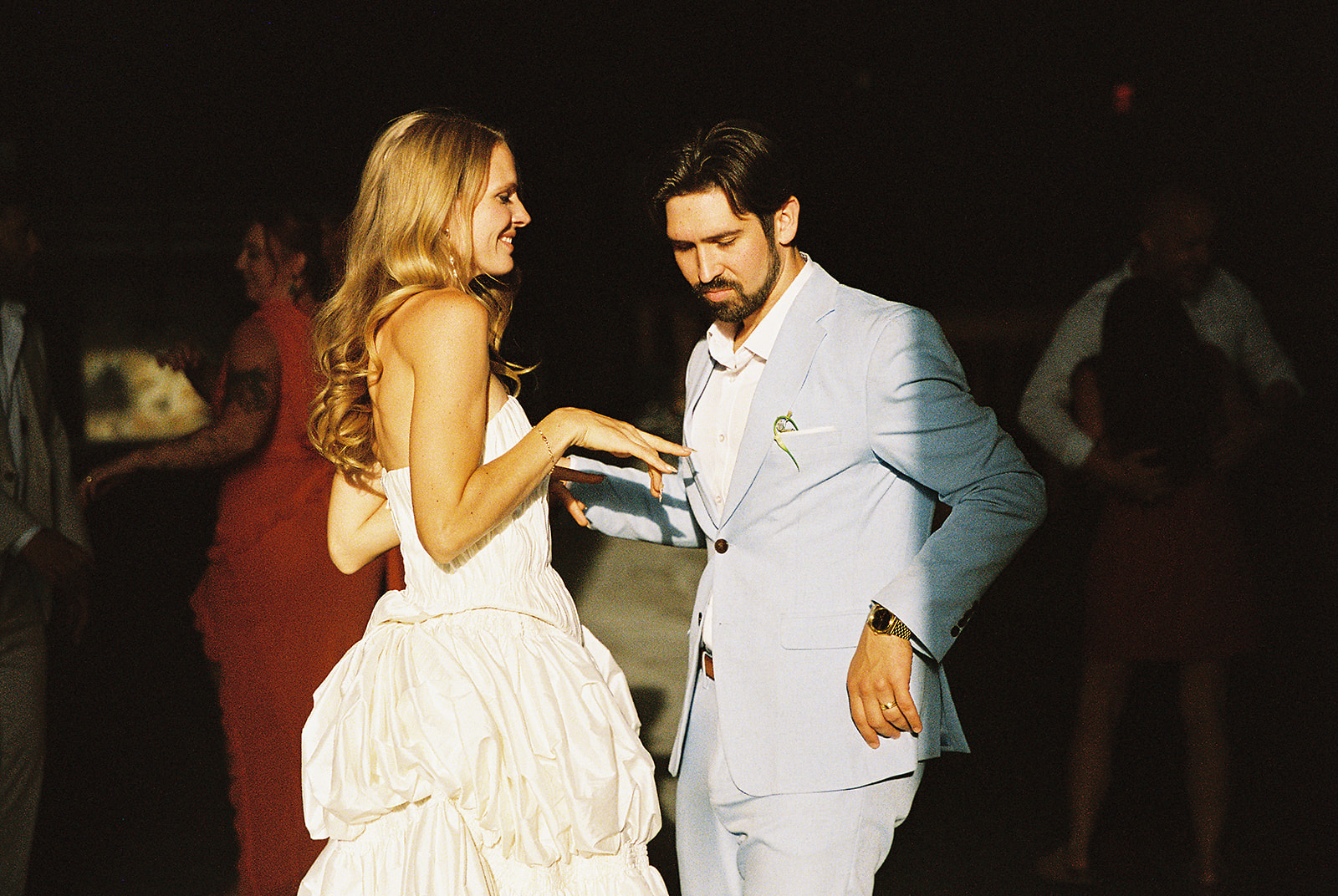 Couple dancing during a wedding reception inside Maysara Winery, with the bride in a white gown and groom in a light blue suit.