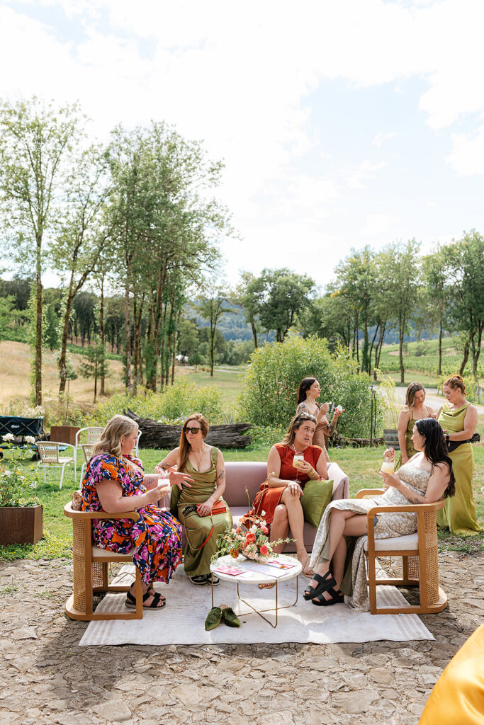 Guests relaxing in an outdoor cocktail hour lounge beside the vineyards at Maysara Winery.
