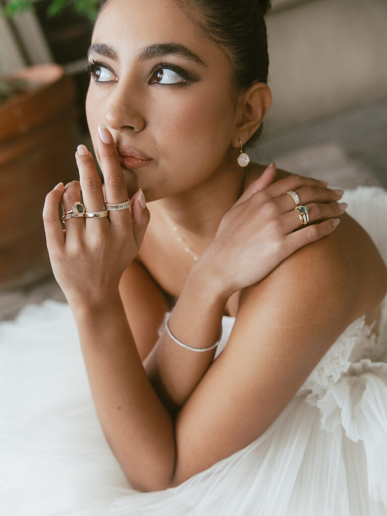Bride posed in a voluminous white tulle gown with rings on her fingers.