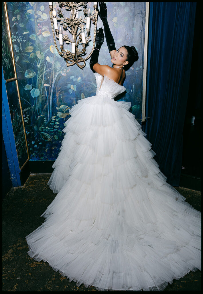 Bride posing in front of a blue painted wall inside The Ruins in Seattle for a wedding editorial.
