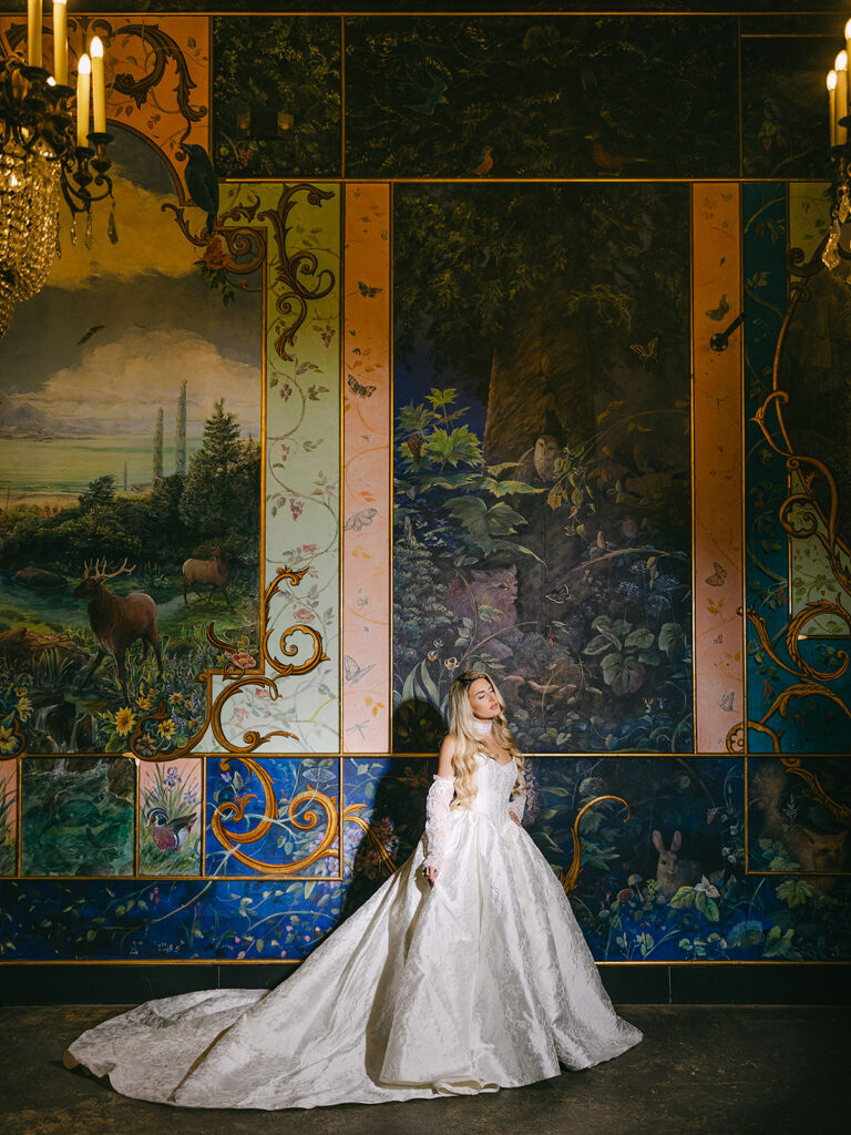 Bride posing in front of an elegant and colorful mural inside The Ruins in Seattle for a wedding editorial.