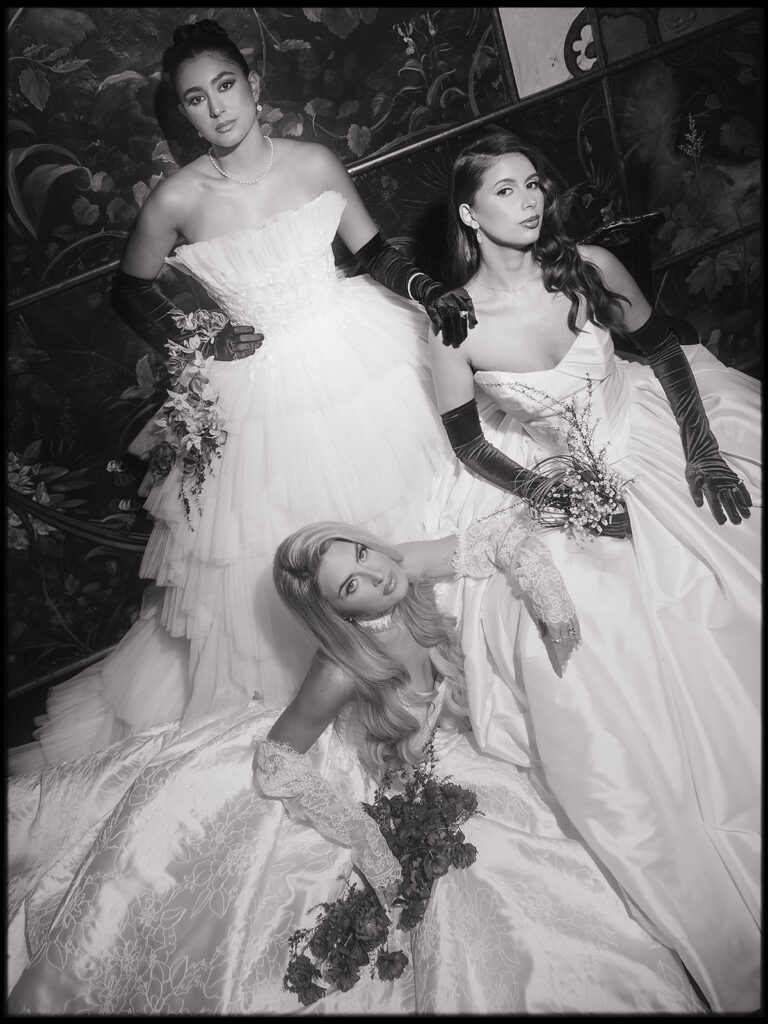 Black and white flash photo of three brides posing inside The Ruins wedding venue in Seattle, WA.